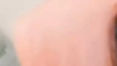 The naked girl fingers her wet pussy during a video call sex